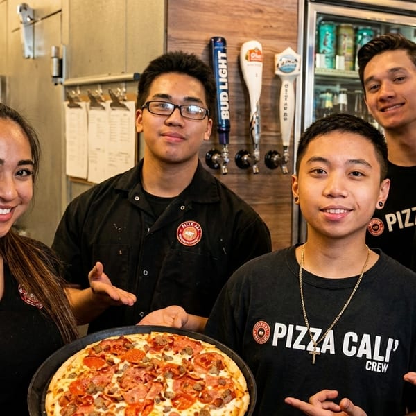 Five smiling Pizza Cali crew members, one holding a freshly baked pepperoni and sausage pizza.